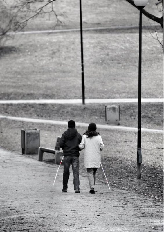 Para spacerująca z laskami dla osób niewidomych